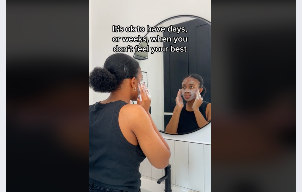 screenshot from dove's tiktok video with a woman of colour applying a dove product and saying some affirmations in front of the mirror