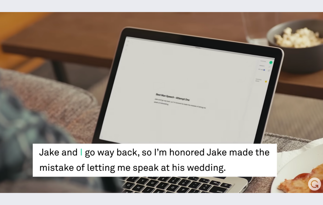 screenshot from grammarly's youtube video showing someone holding a laptop while using grammarly