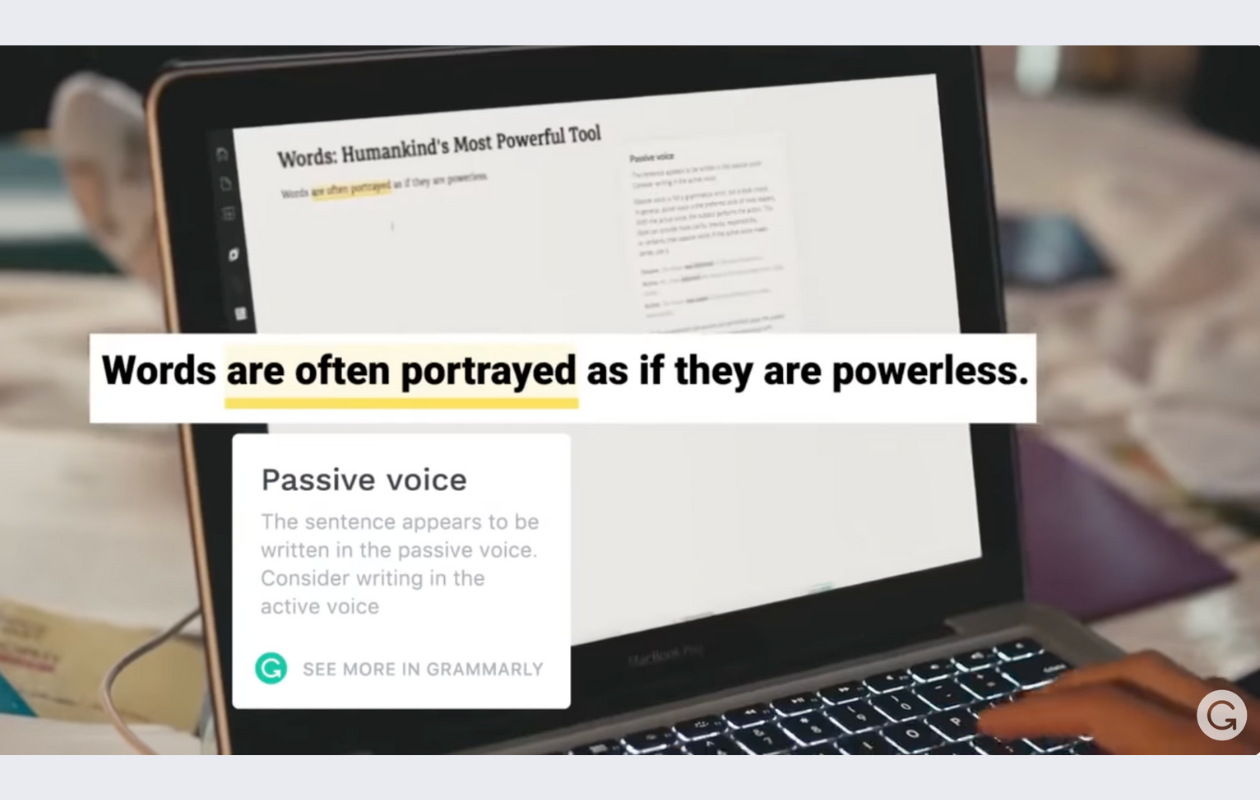 screenshot from grammarly's youtube video with a laptop on a desk opened in grammarly showing texts about passive voice